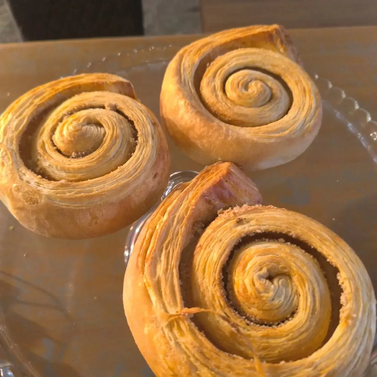 Tres rollos de canela están sobre un plato de vidrio.