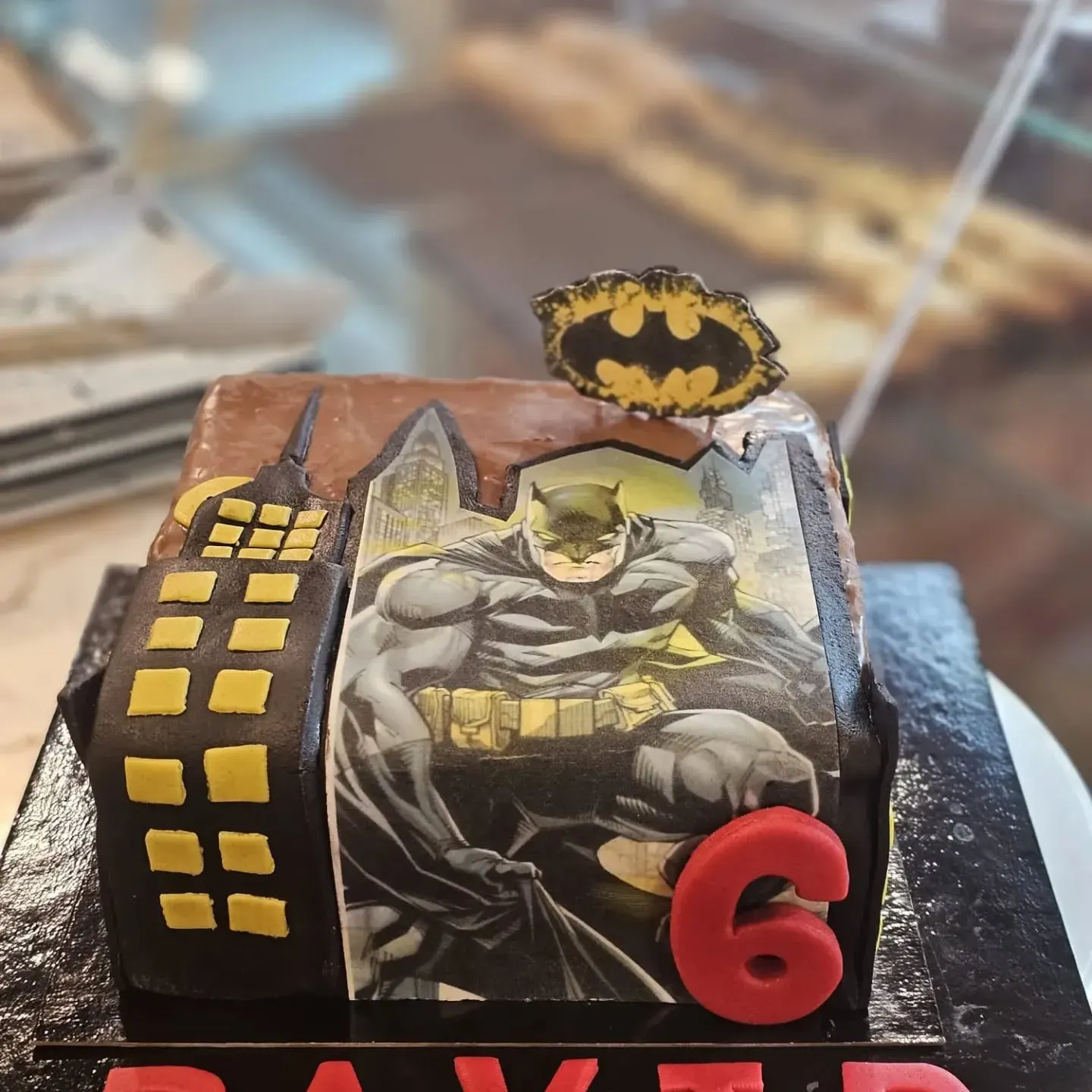 Un pastel con una imagen de Batman y el número 6