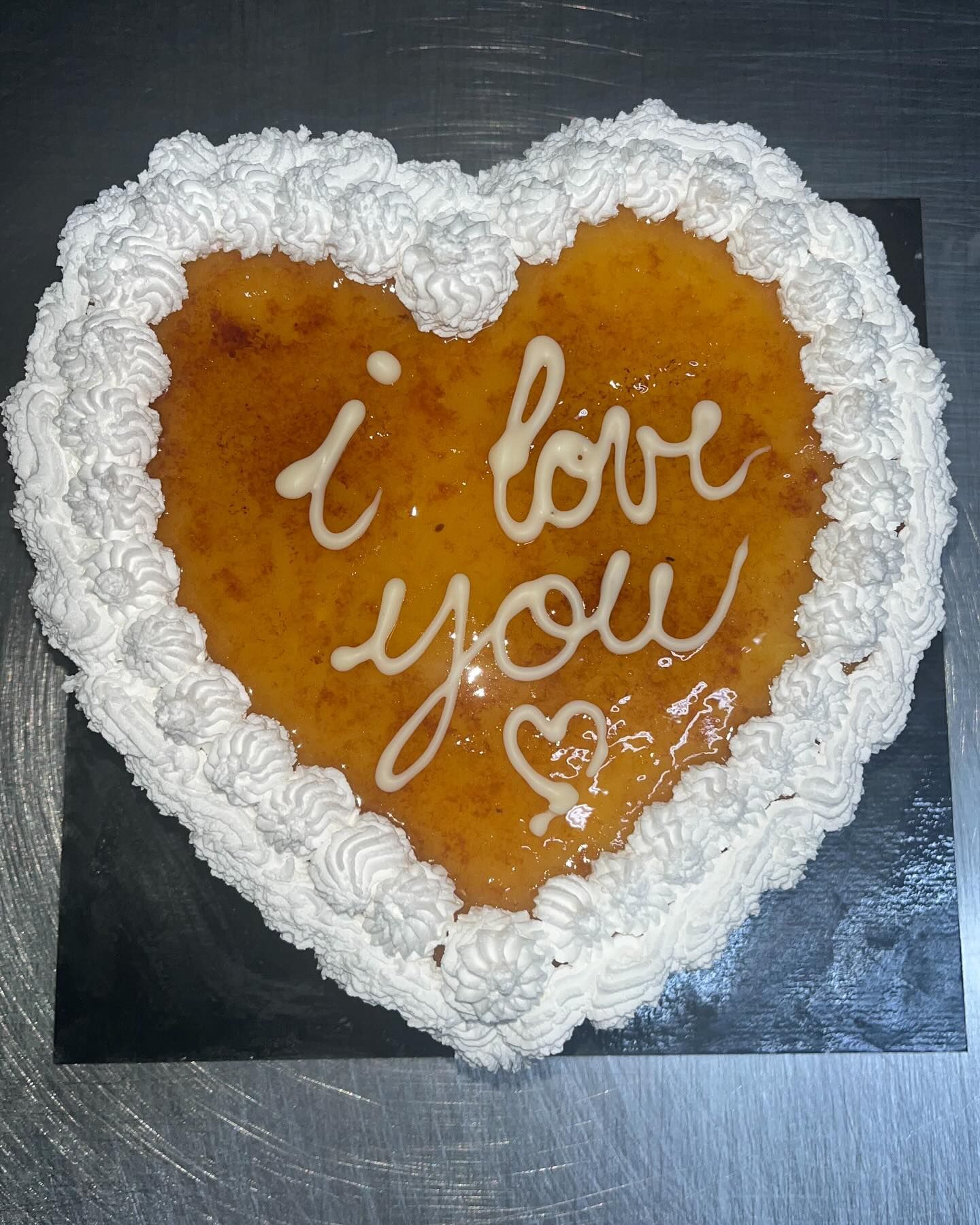 Un pastel en forma de corazón que dice te amo
