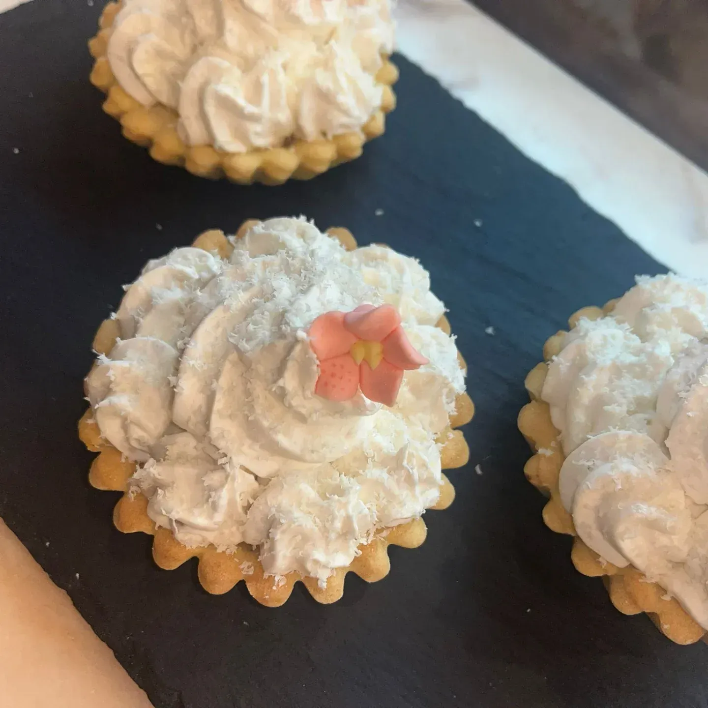 Tres cupcakes con crema batida y una flor encima