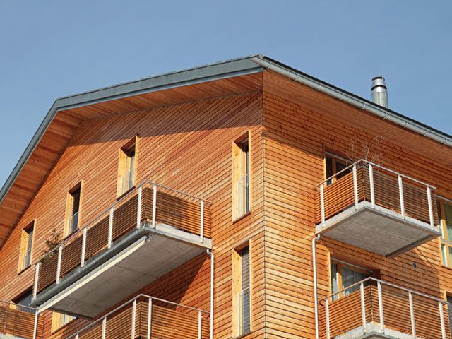 Ein Holzgebäude mit Balkonen und einem Schornstein auf dem Dach