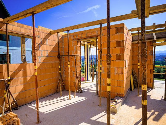 Ein Haus wird aus Ziegeln und Holzbalken gebaut.