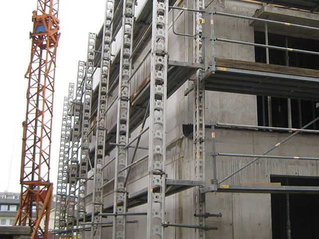 Ein im Bau befindliches Gebäude mit Gerüsten und einem Kran im Hintergrund