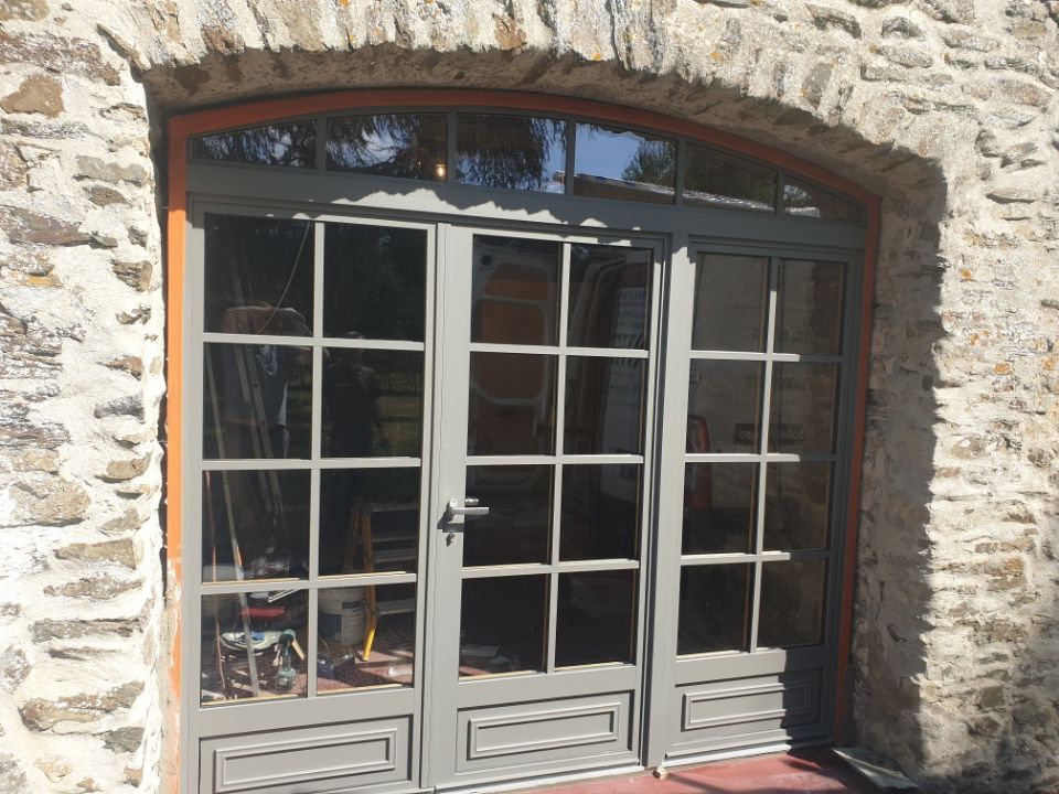 Trois grandes portes-fenêtres grises avec des petits carreaux