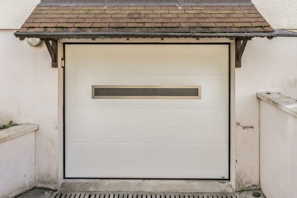 Porte de garage basculante blanche avec vitre centrale