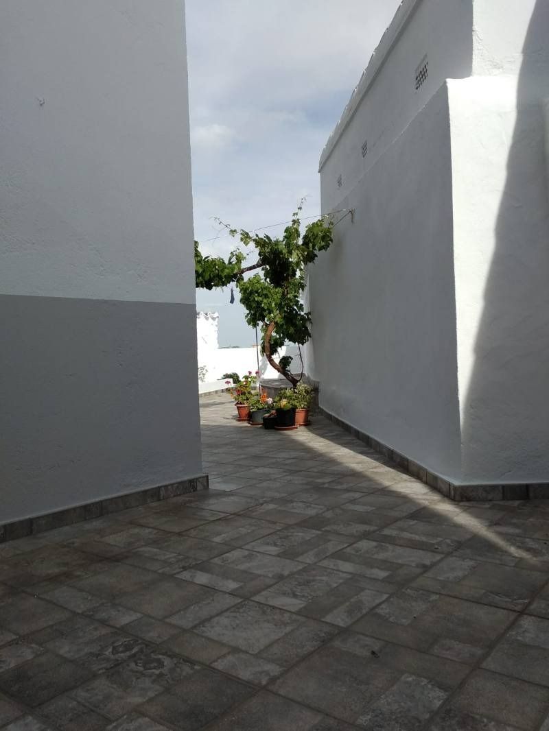 Un callejón estrecho entre dos edificios blancos