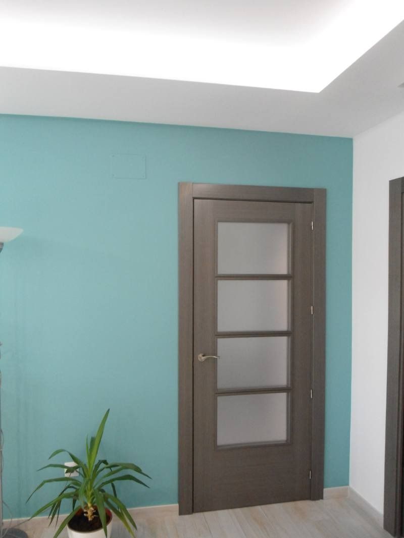 Una habitación con una puerta y una planta en una maceta.