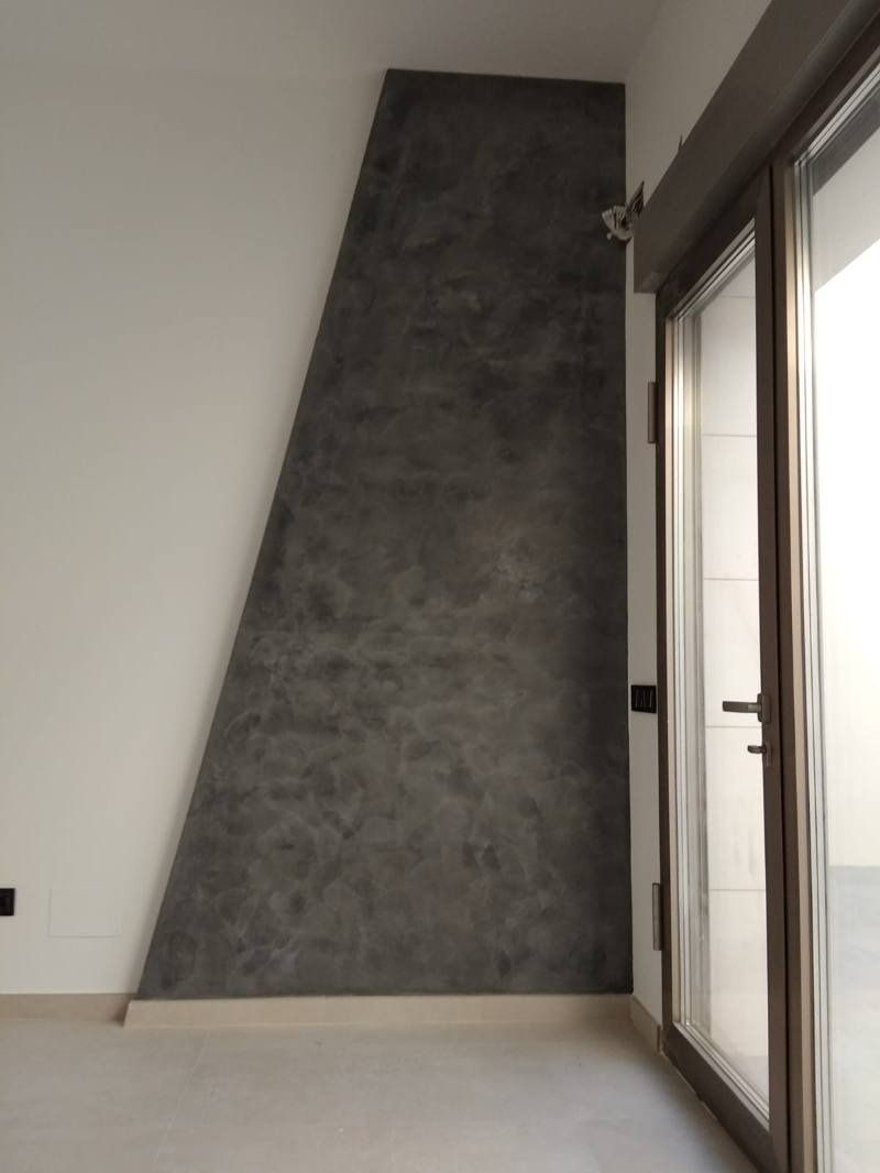 Una habitación con una puerta corrediza de vidrio y una pared gris.