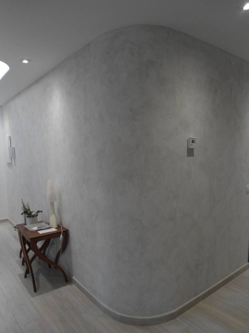 Un pasillo con una mesa y una planta encima.