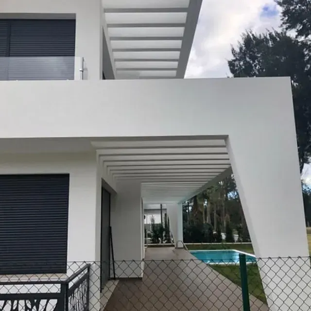 Una casa blanca con una valla y una piscina.