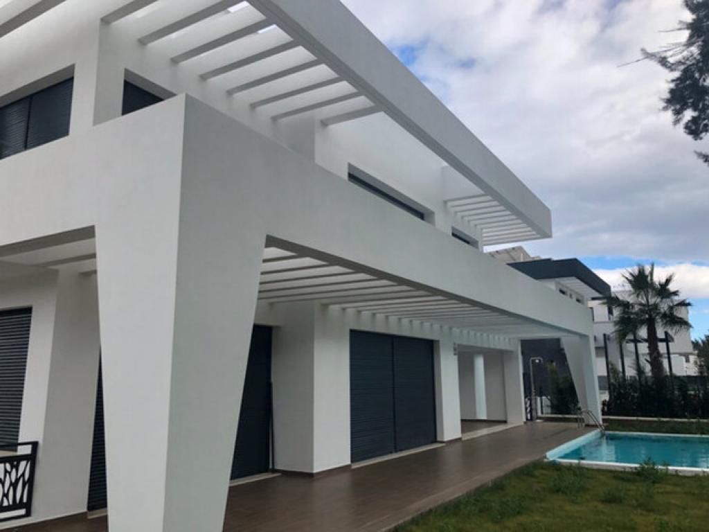 Una gran casa blanca con piscina en el patio trasero.