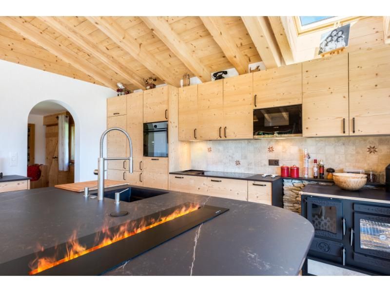 Une cuisine avec des armoires en bois, un évier et une cheminée.