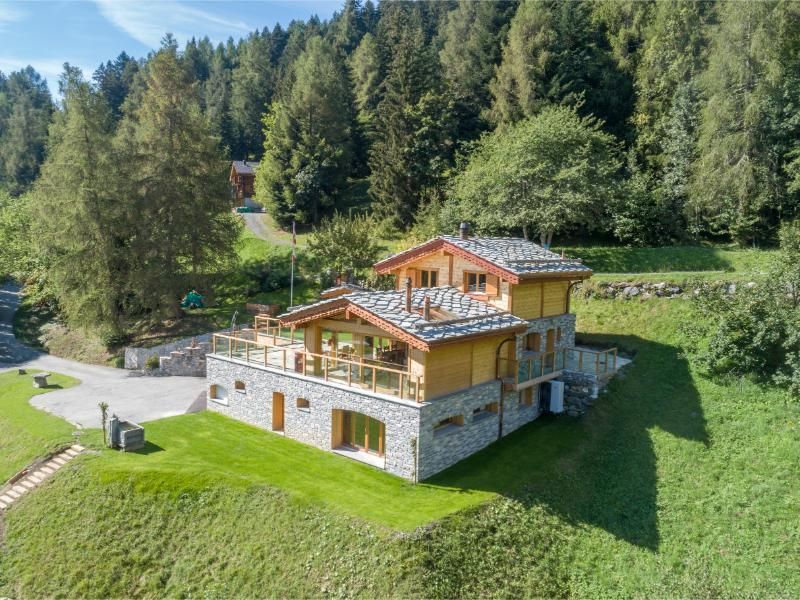 Une vue aérienne d'une grande maison au milieu d'une forêt.