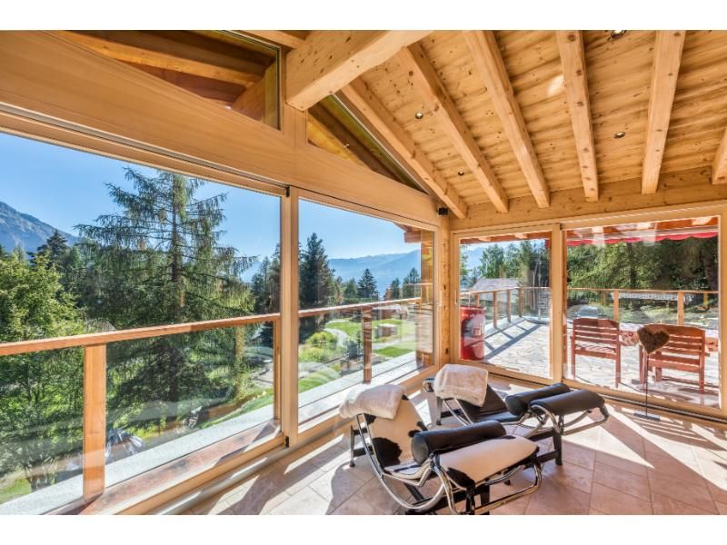 Une pièce avec beaucoup de fenêtres et une chaise dedans