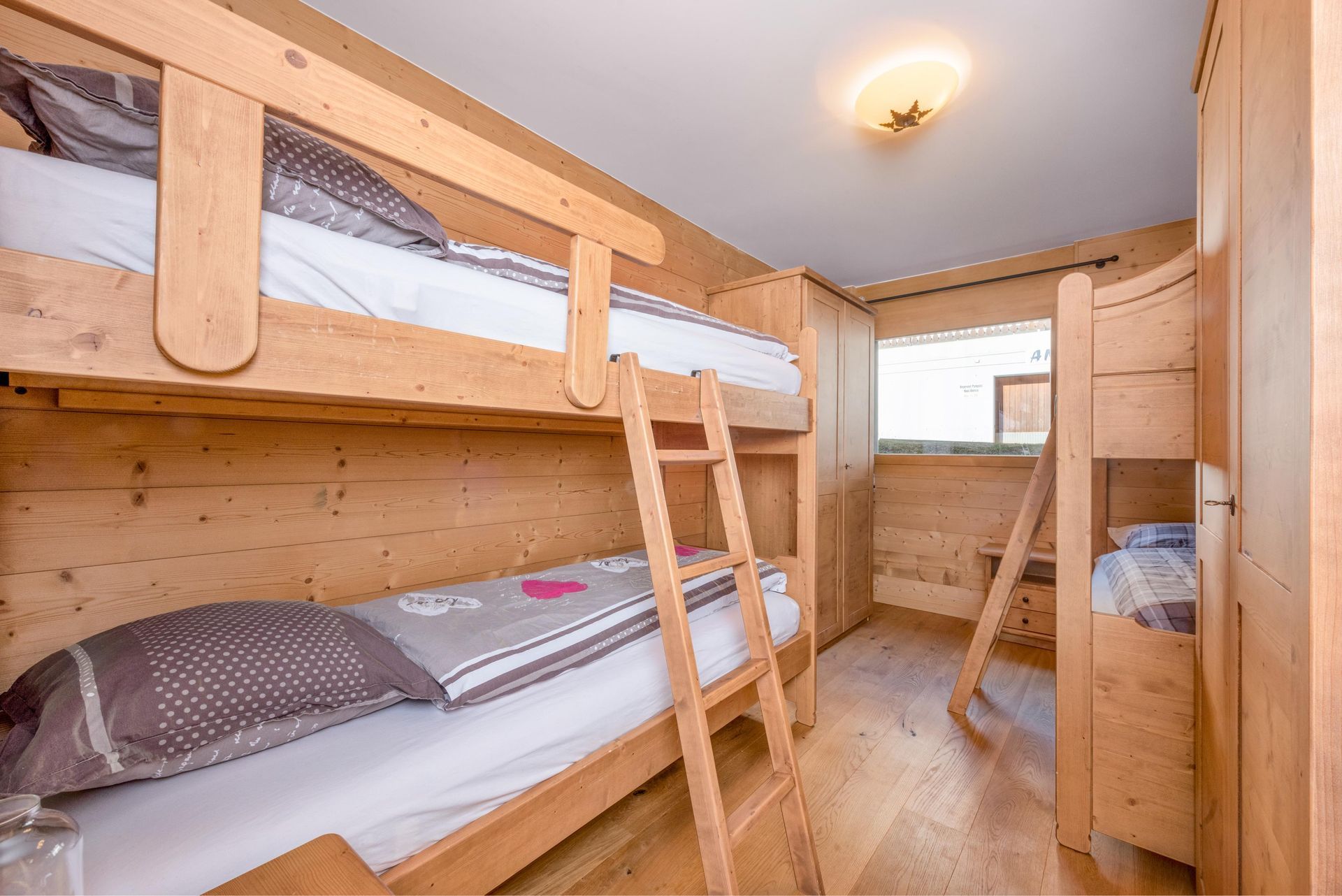 Un lit superposé avec une échelle dans une pièce en bois.