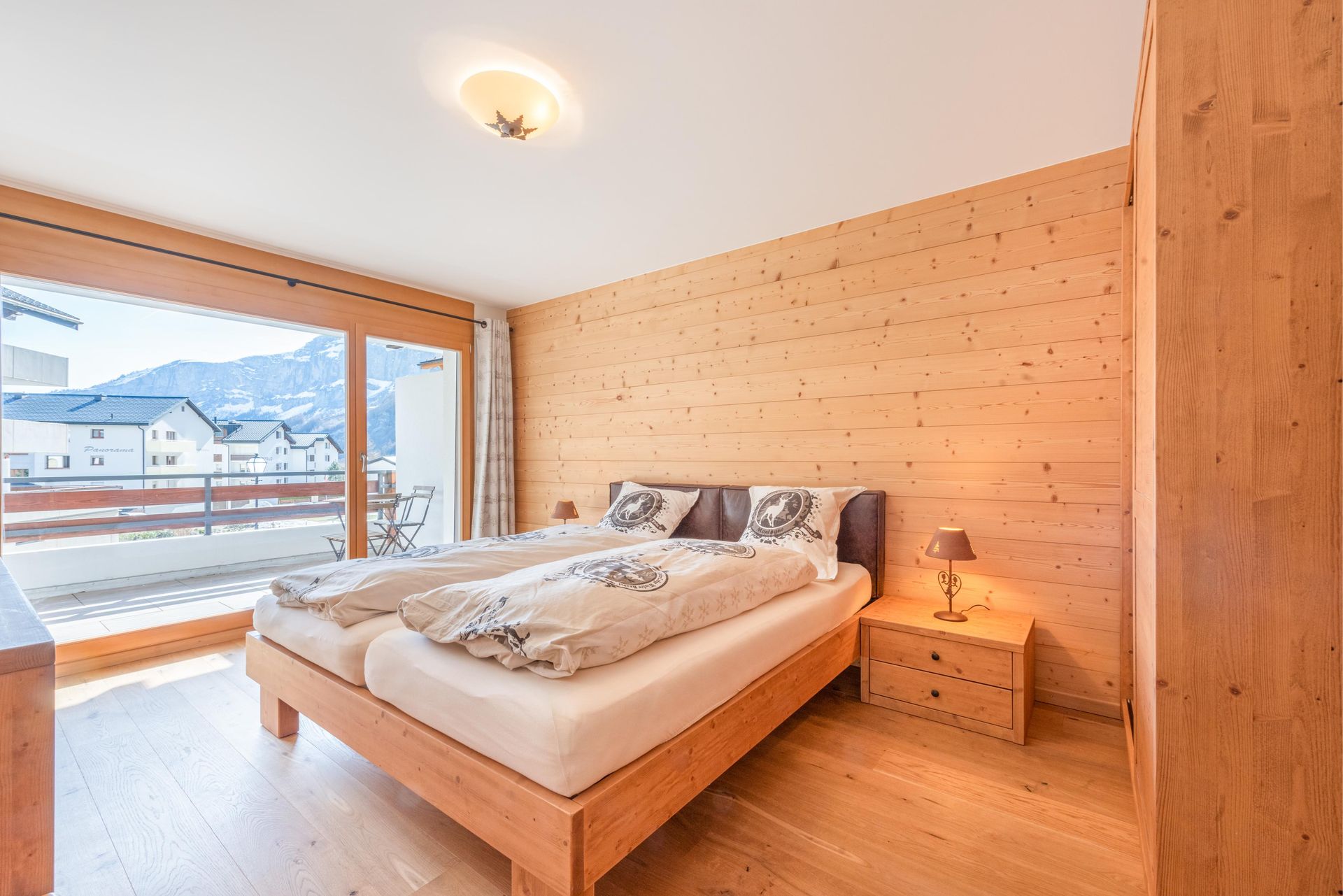 Une chambre avec deux lits, une table de nuit et un balcon.