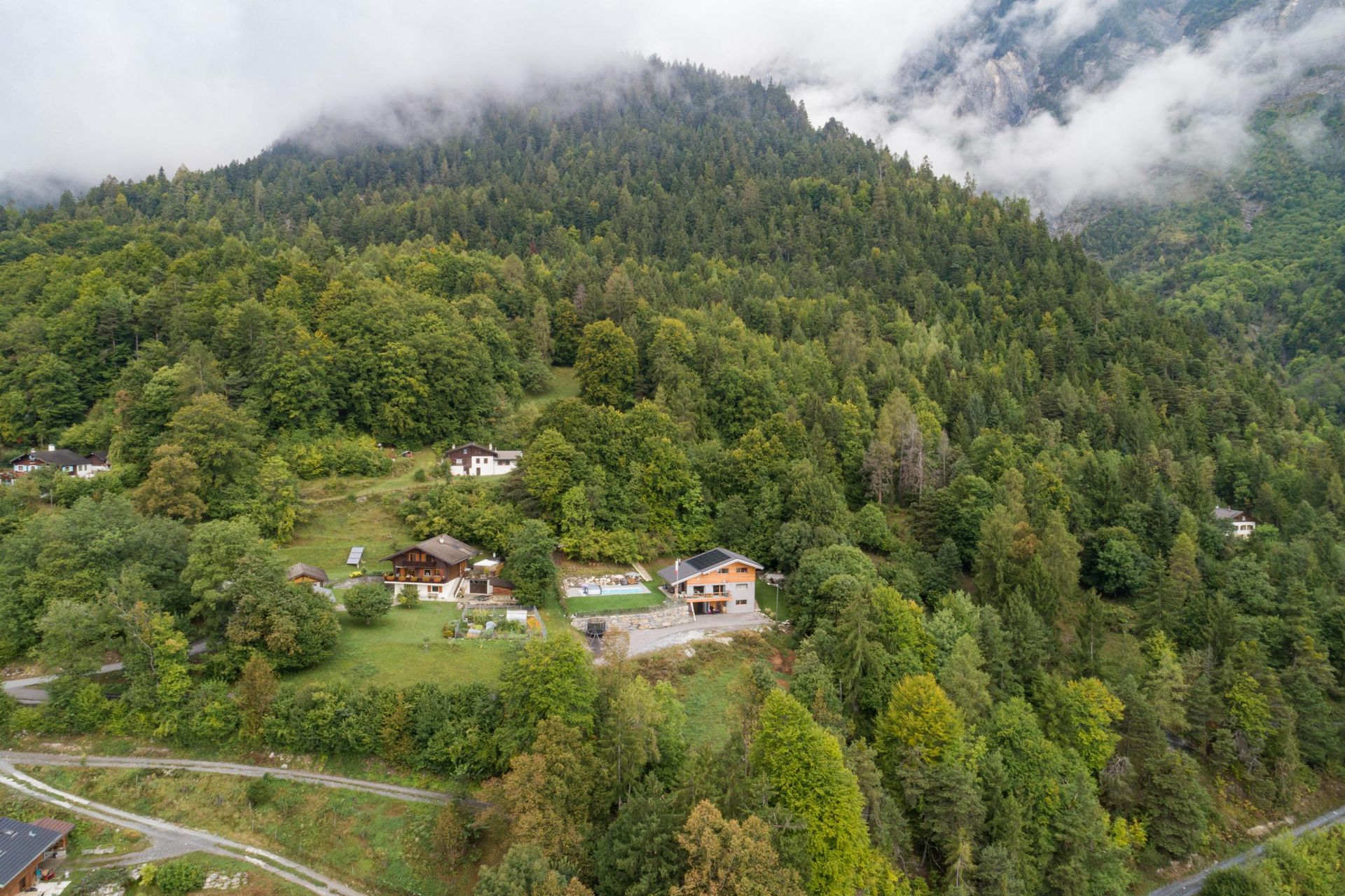 Une vue aérienne d'une maison au milieu d'une forêt.