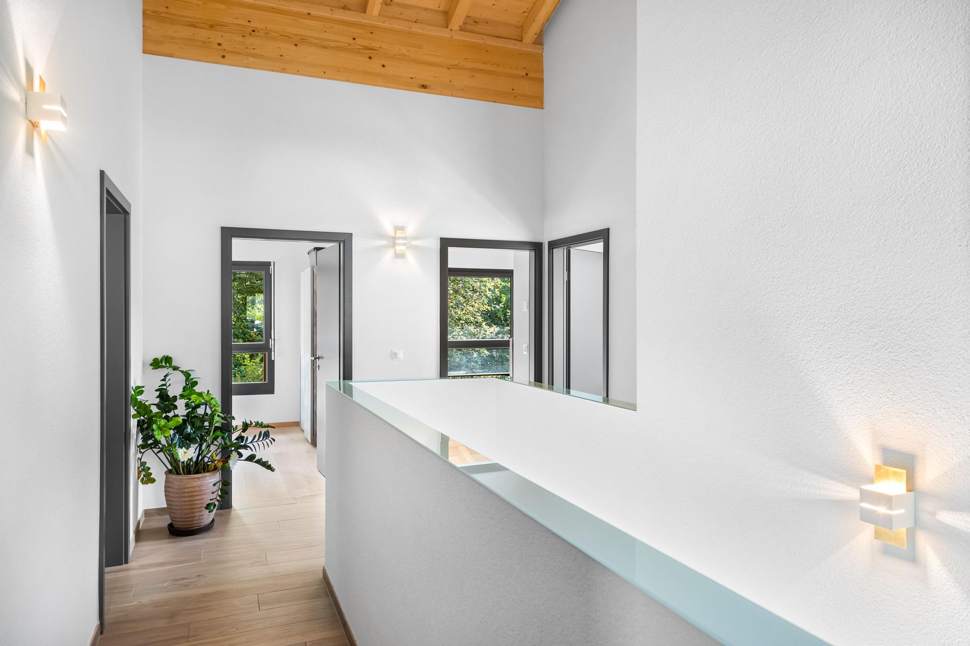 Un couloir dans une maison avec un plafond en bois et des murs blancs.