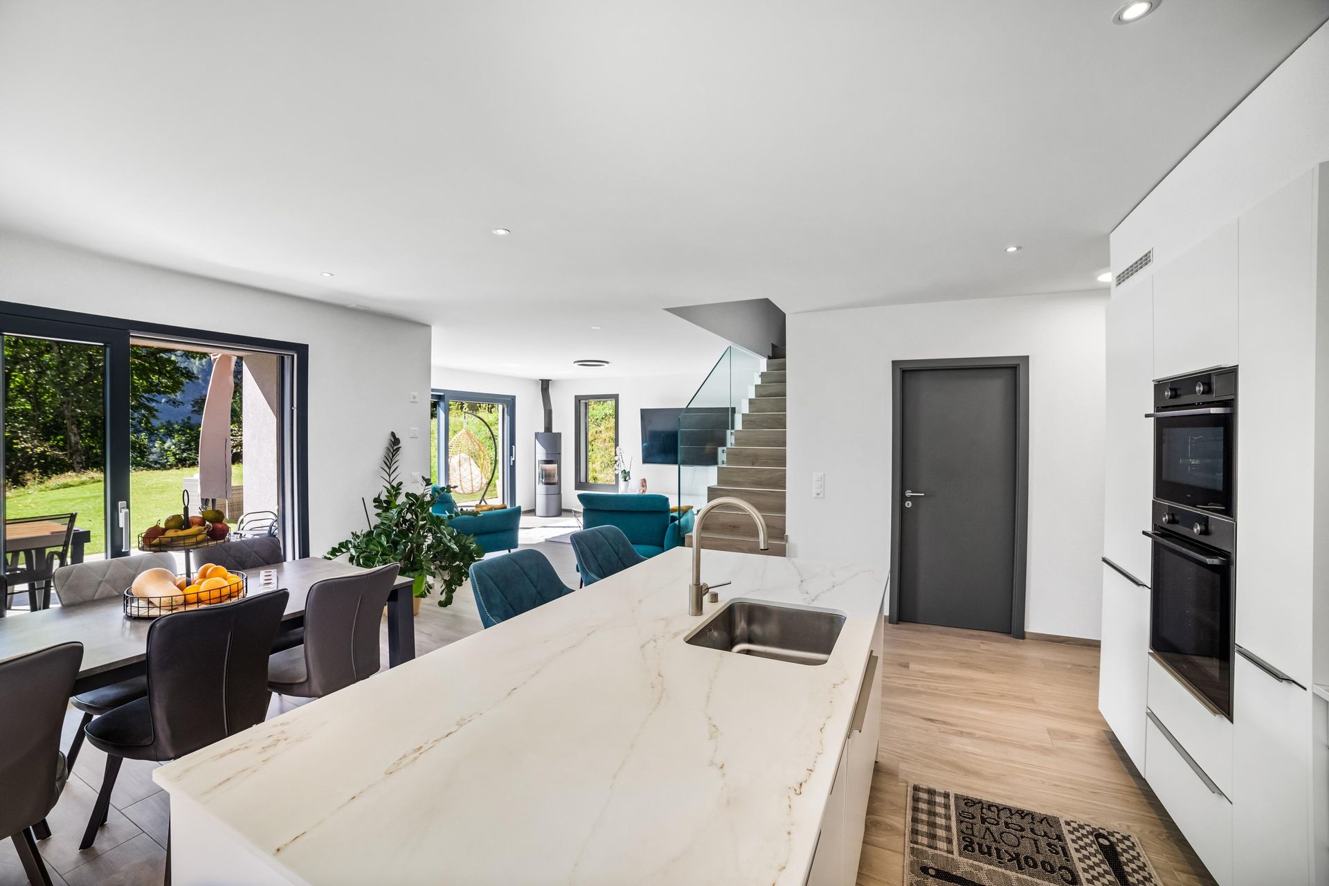 Une cuisine avec un évier, une cuisinière, une table à manger et des chaises.