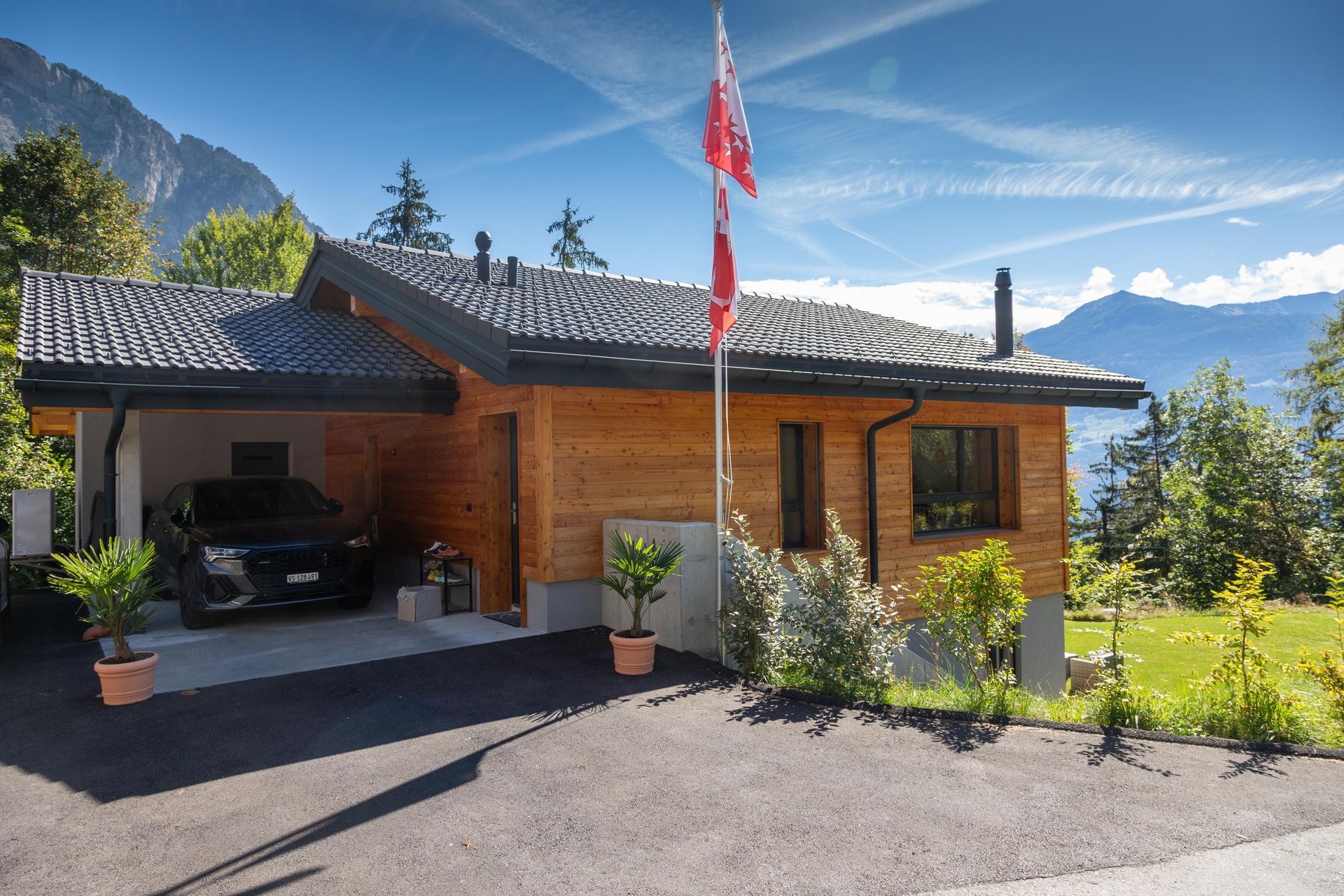Une maison en bois avec une voiture garée devant