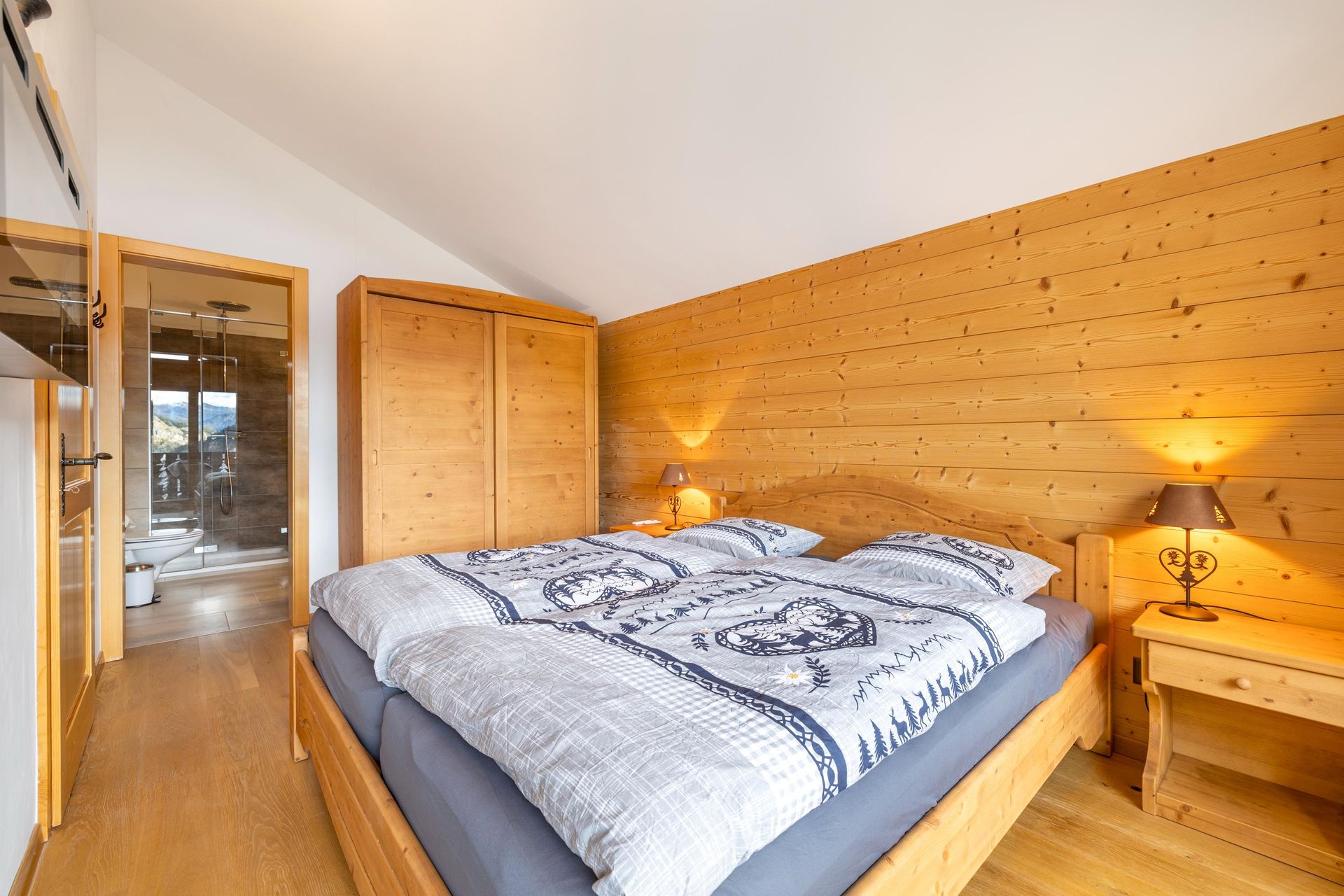 Une chambre avec un grand lit et un mur en bois.