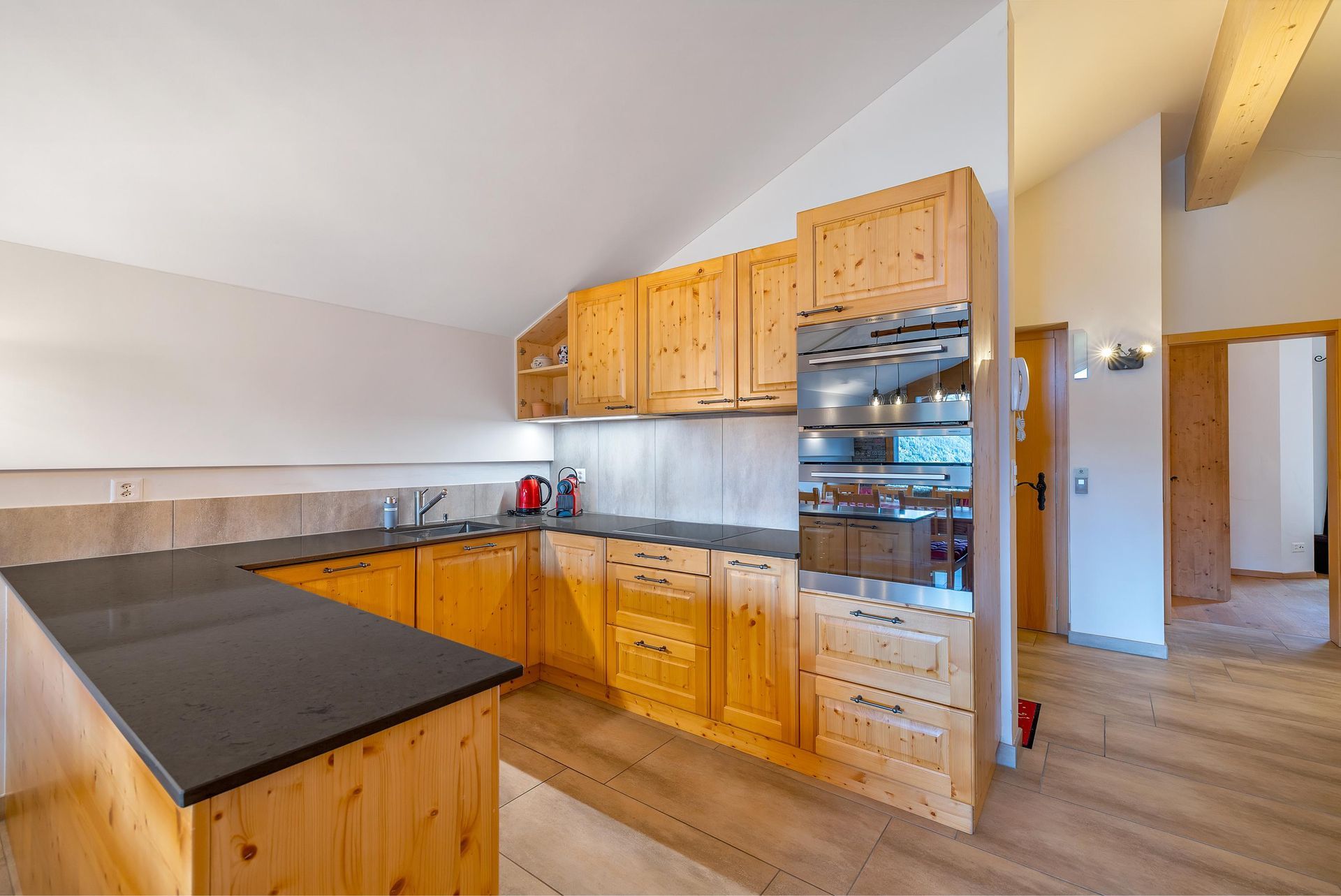 Une cuisine avec des armoires en bois et un comptoir noir.