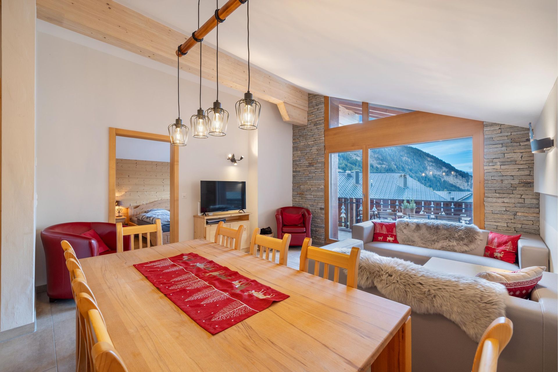 Un salon avec une table à manger et des chaises et une télévision.