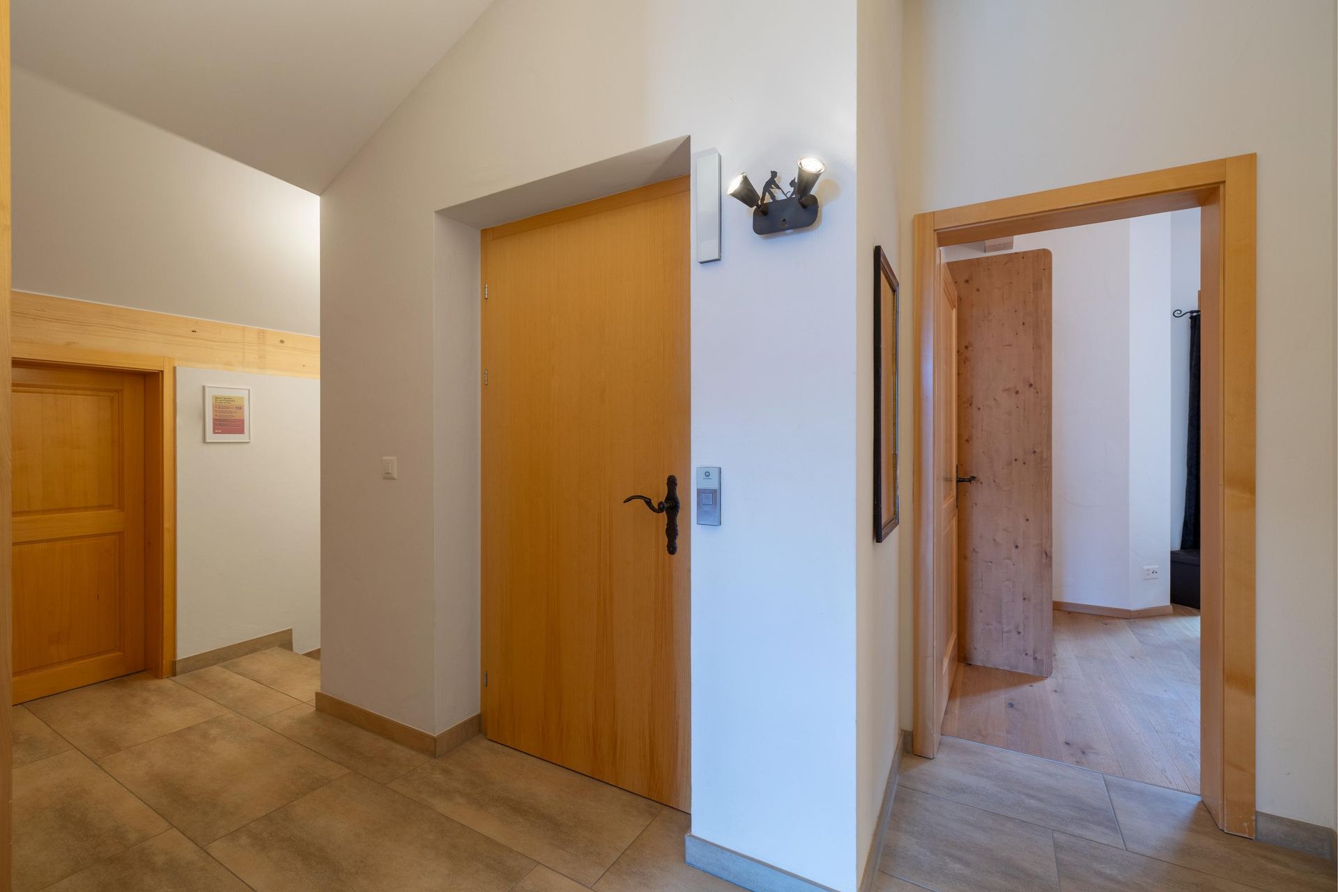 Un couloir avec des portes en bois menant à différentes pièces d'une maison.