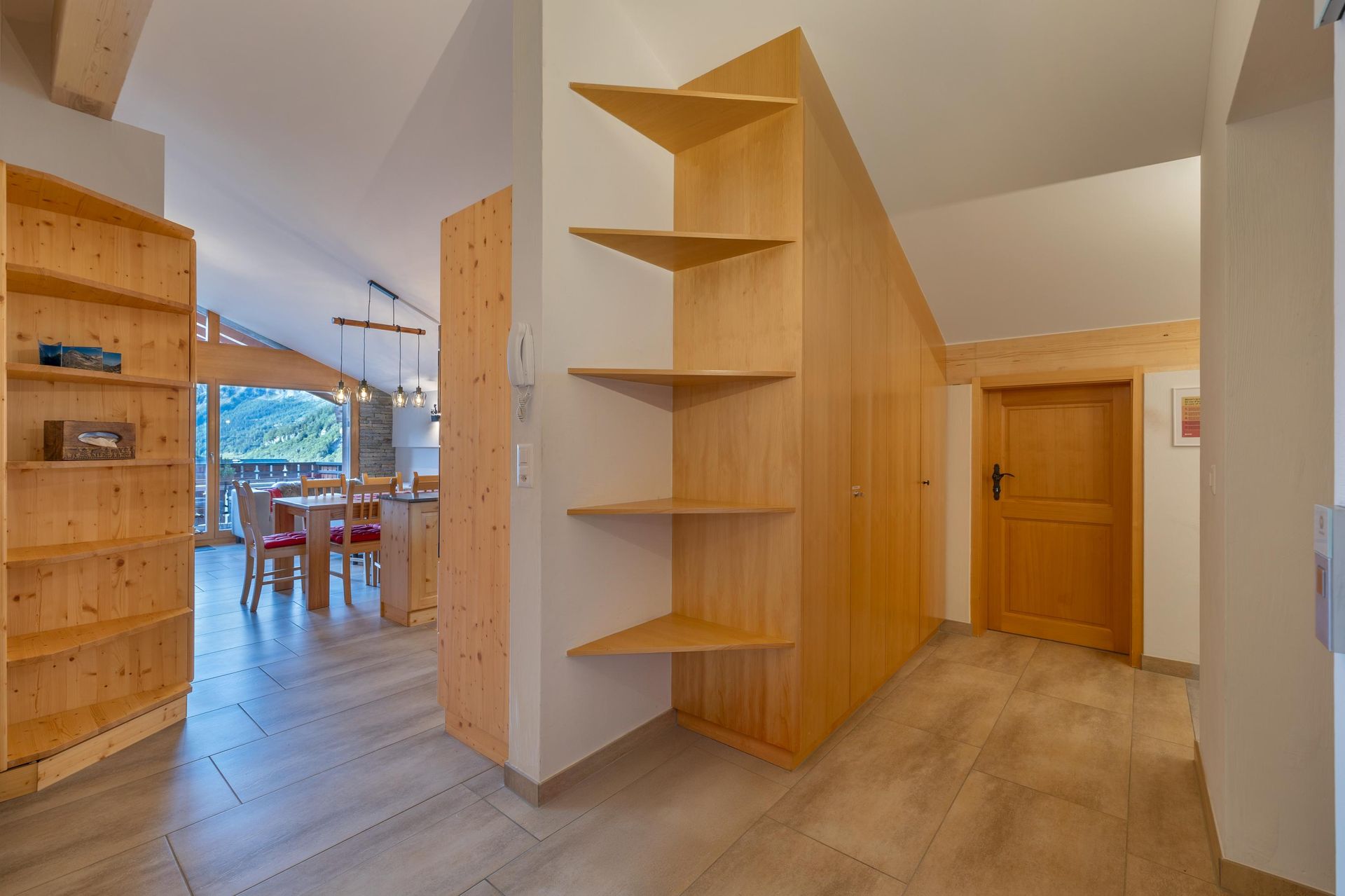 Un couloir avec des étagères en bois et une porte en bois