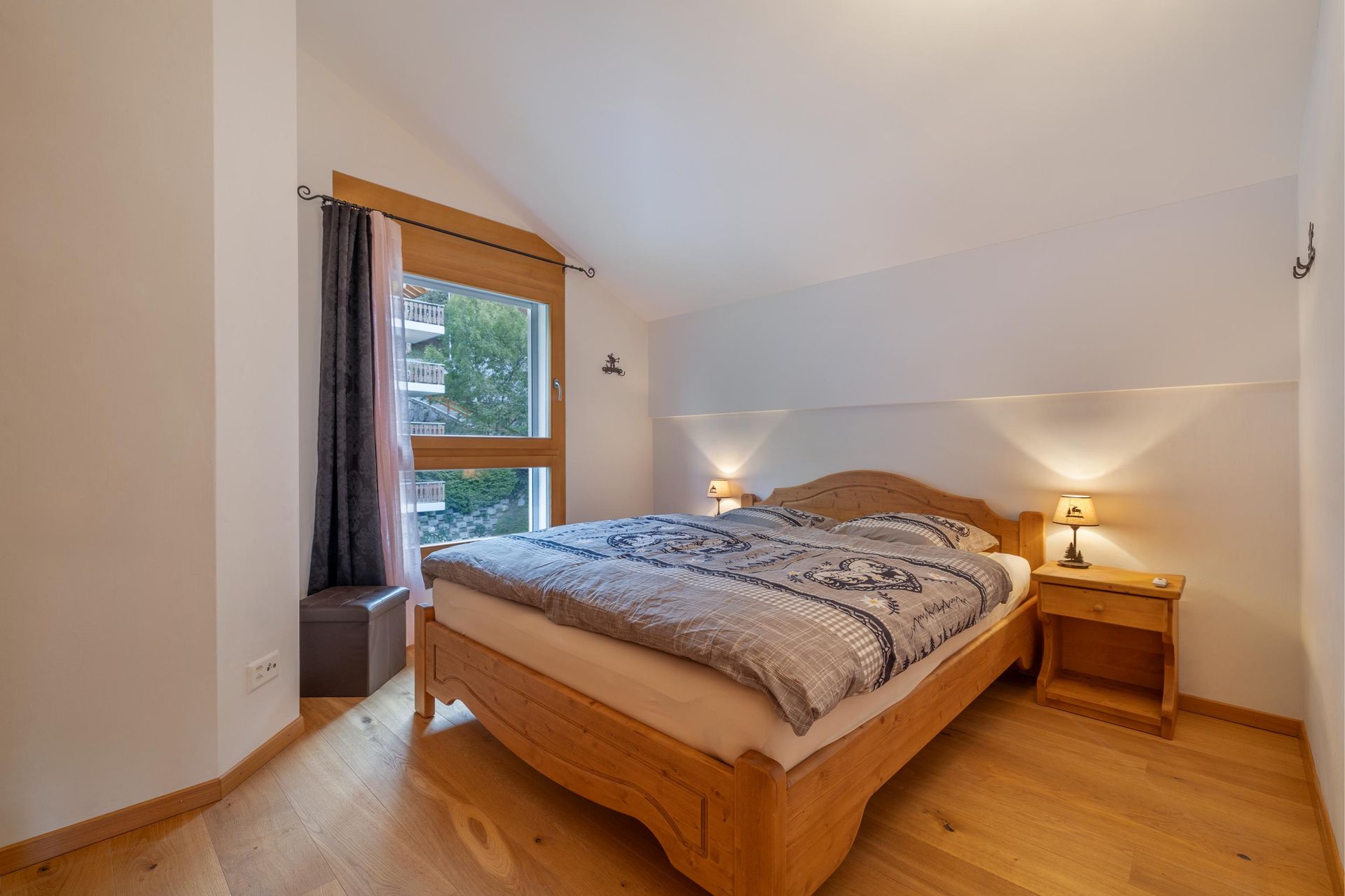 Une chambre avec un lit en bois, une table de nuit et une fenêtre.