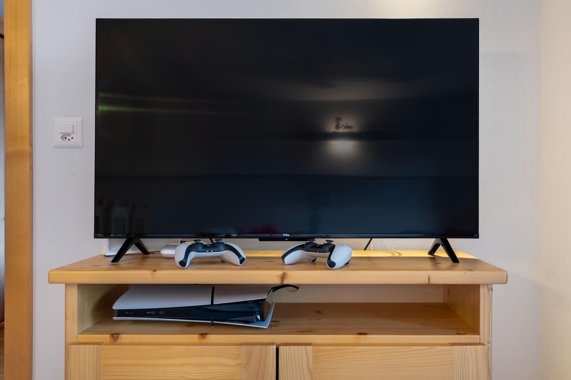 Un téléviseur à écran plat est posé sur un centre de divertissement en bois.