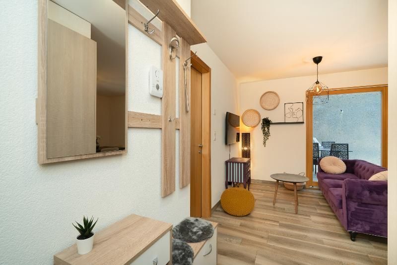 Un salon avec un canapé violet et un miroir