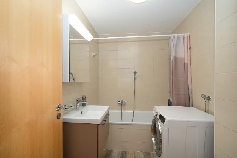 Une salle de bain avec lavabo, baignoire et machine à laver.