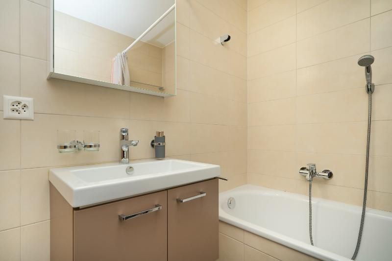 Une salle de bain avec lavabo, baignoire et miroir