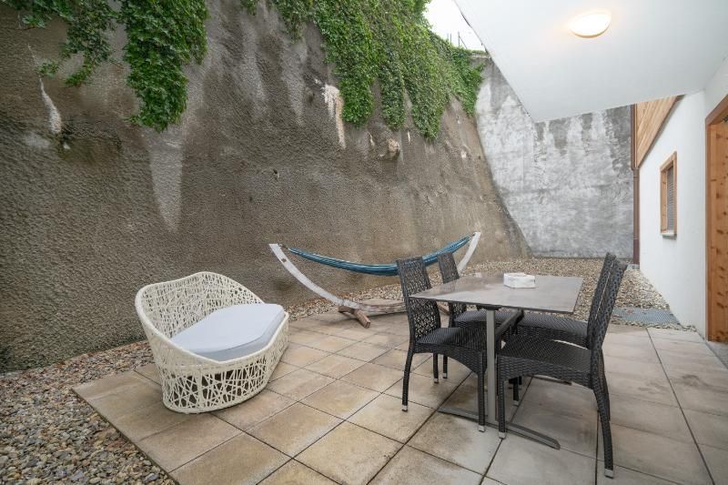 Un patio avec une table et des chaises et un hamac.