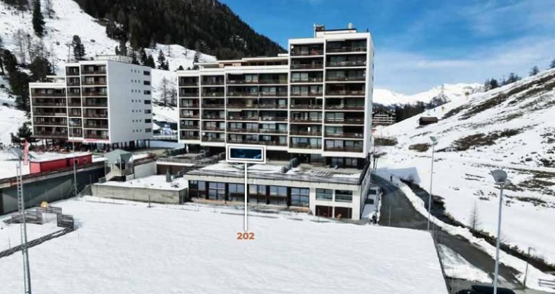 Un grand bâtiment au milieu d'une montagne enneigée.