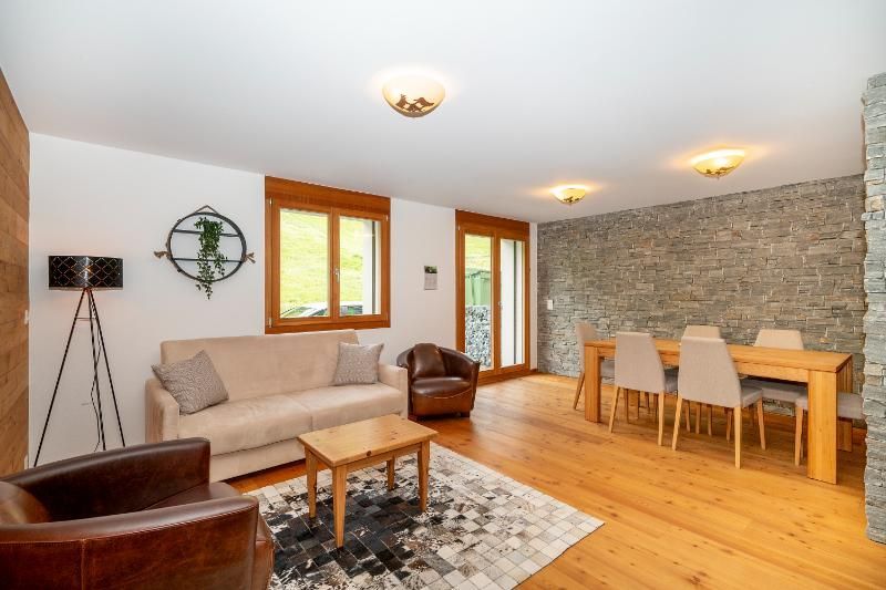 Un salon avec un canapé, une chaise, une table et des chaises.