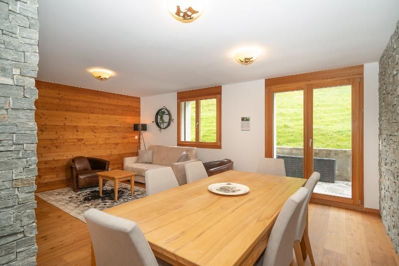 Un salon avec une table et des chaises en bois et un canapé.