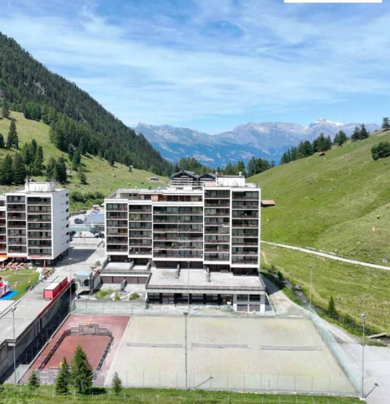 Une vue aérienne d'un bâtiment avec des montagnes en arrière-plan