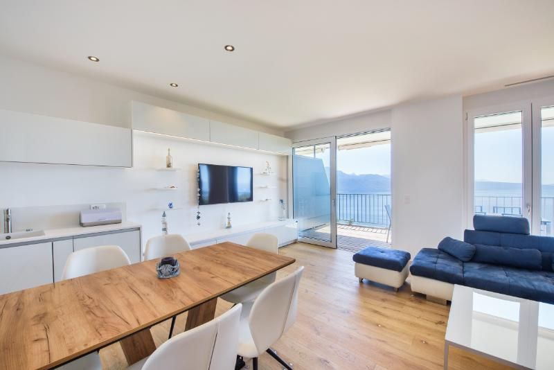 Un salon avec une table à manger, un canapé et une télévision.