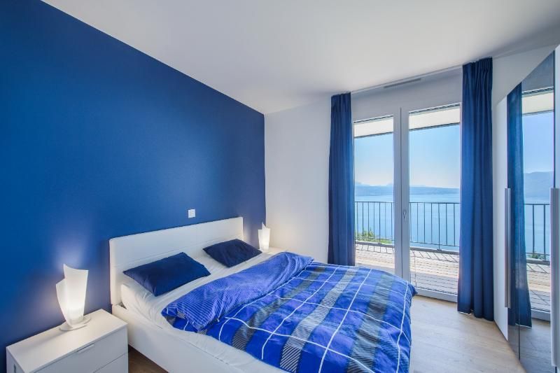 Une chambre avec des murs bleus et un lit avec une couette bleue.