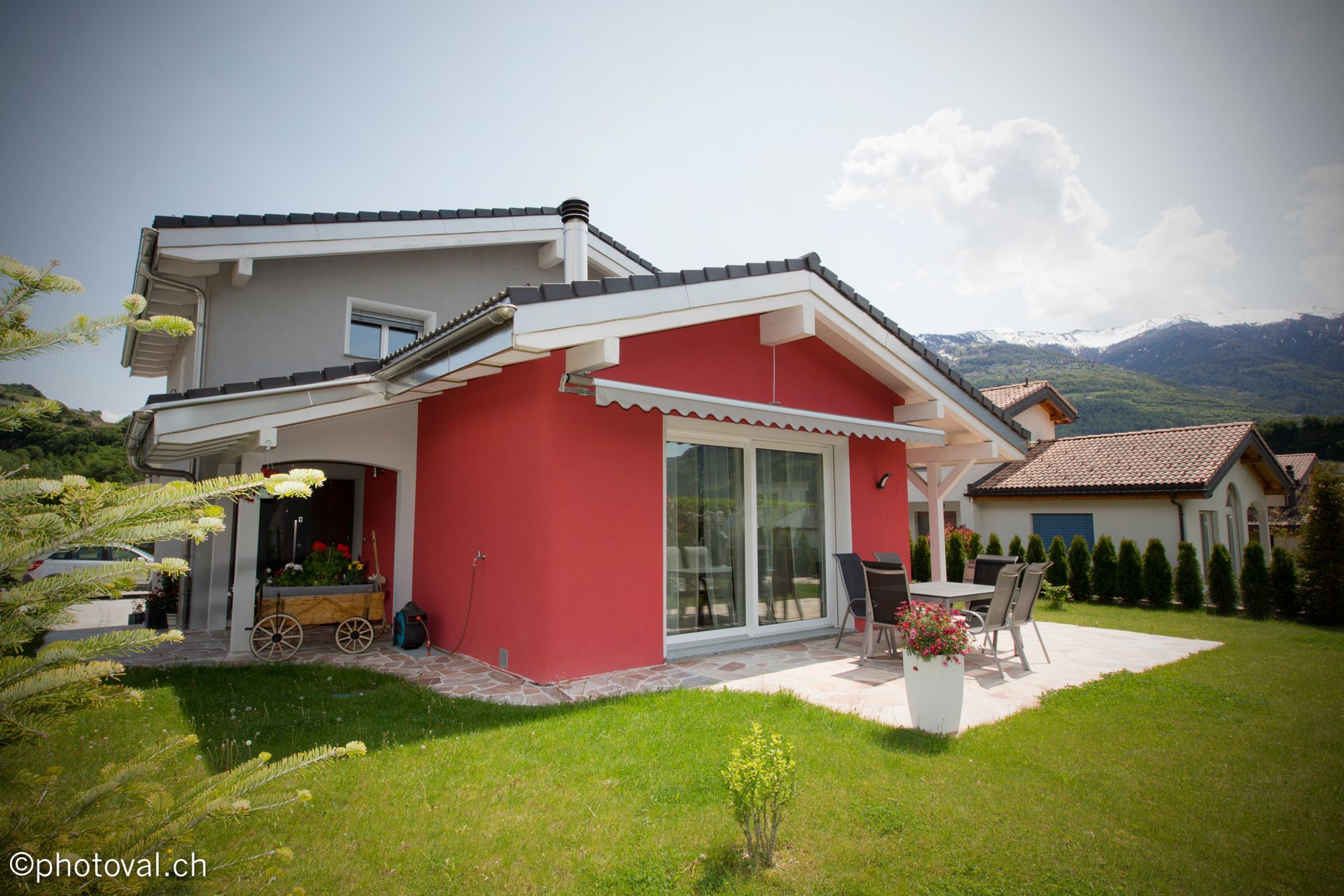 Une maison rouge avec un patio devant