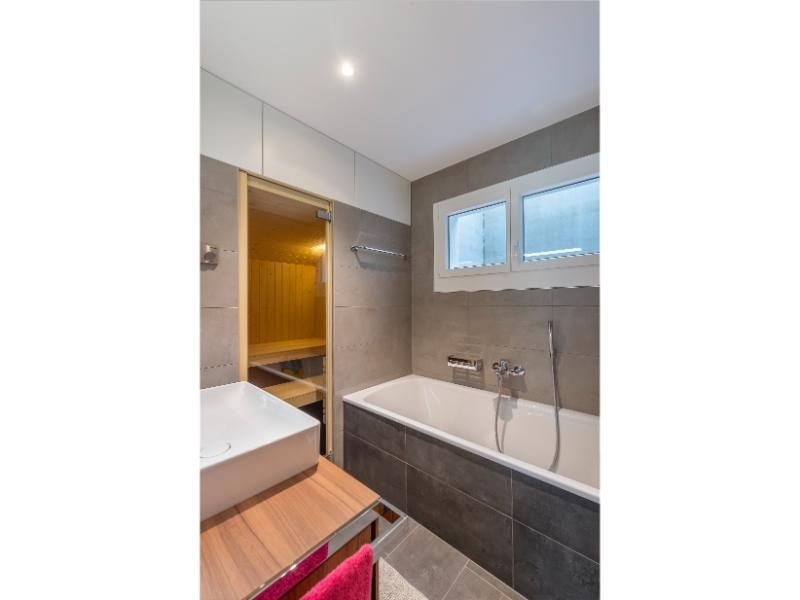 Une salle de bain avec baignoire, lavabo et sauna.