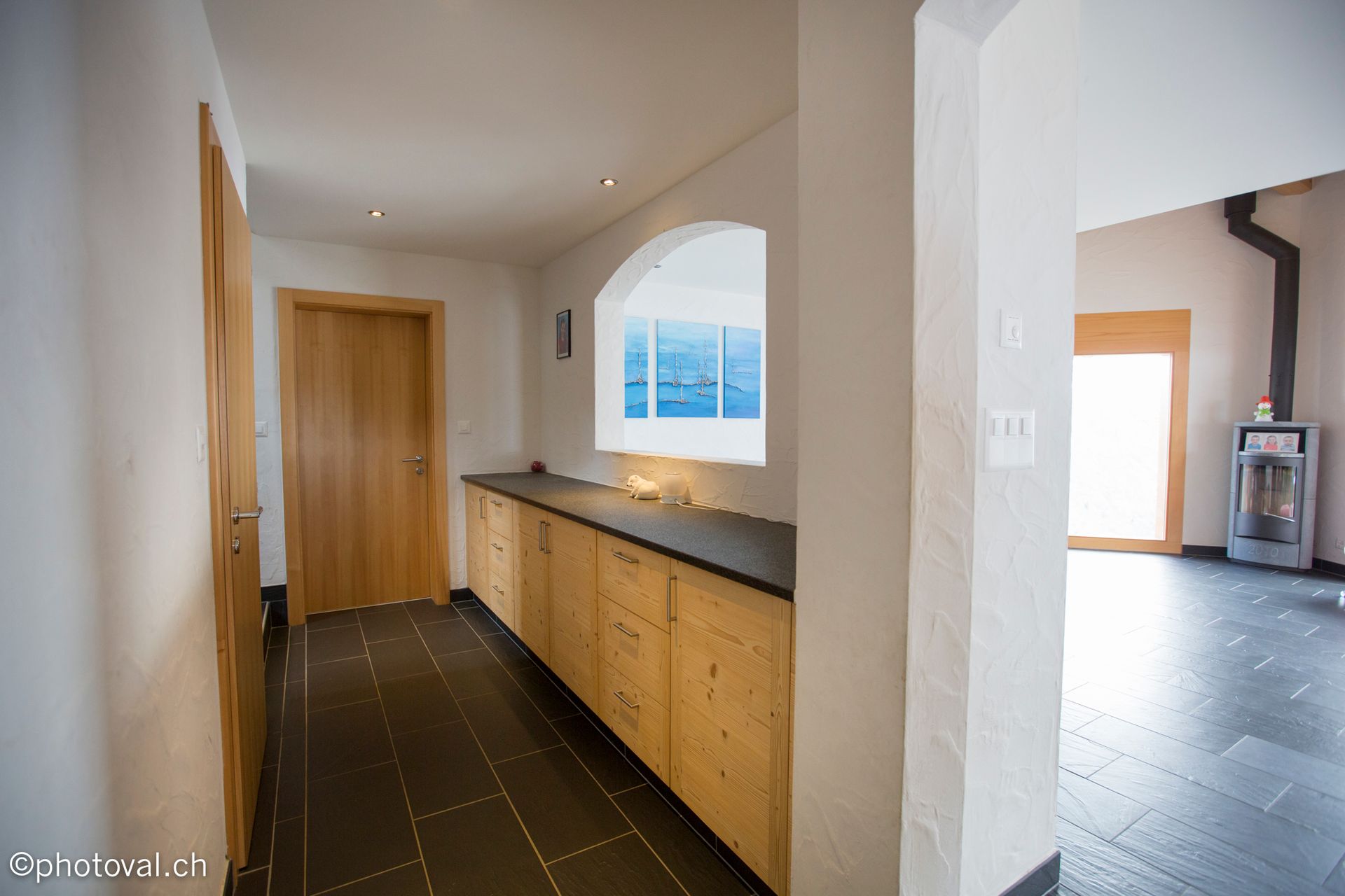 Un couloir dans une maison avec des armoires en bois et une cheminée