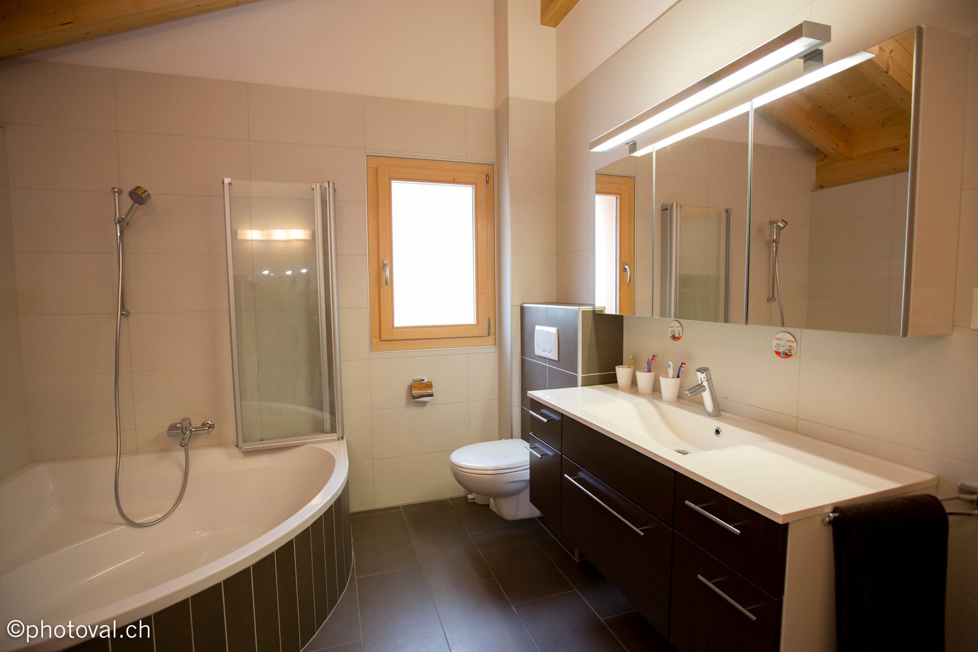 Une salle de bain avec baignoire, lavabo, toilettes et fenêtre