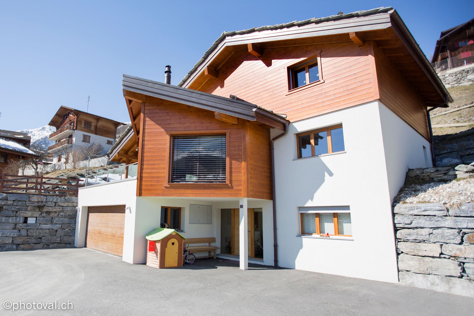 Une grande maison blanche avec un toit en bois