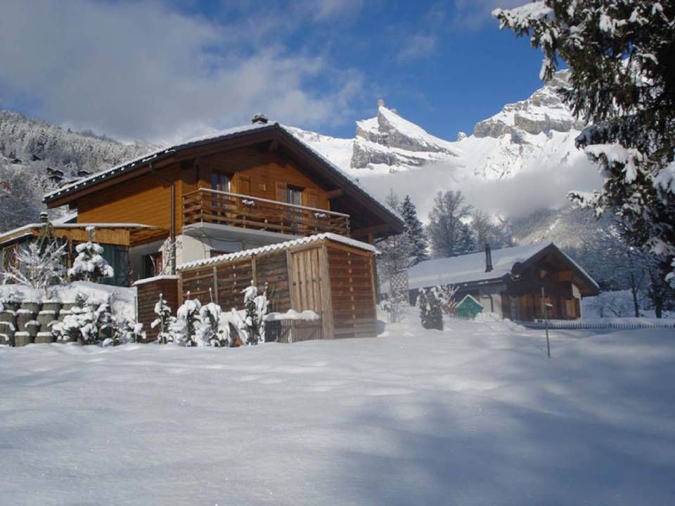 Une maison sous la neige avec une montagne en arrière-plan