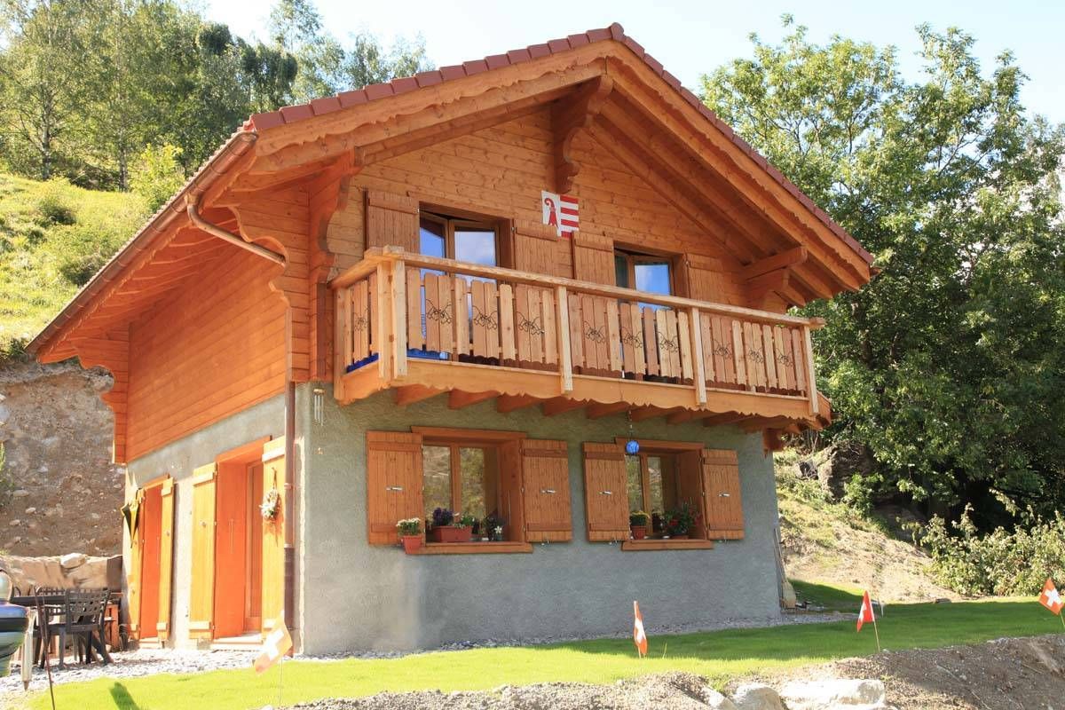 Une maison en bois avec un balcon au sommet