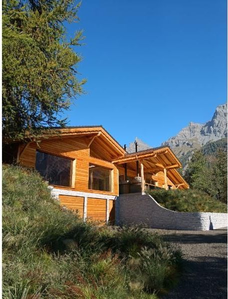 Une maison en bois avec une montagne en arrière-plan