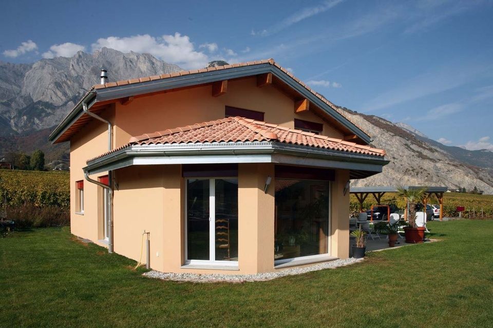 Une petite maison avec des montagnes en arrière-plan